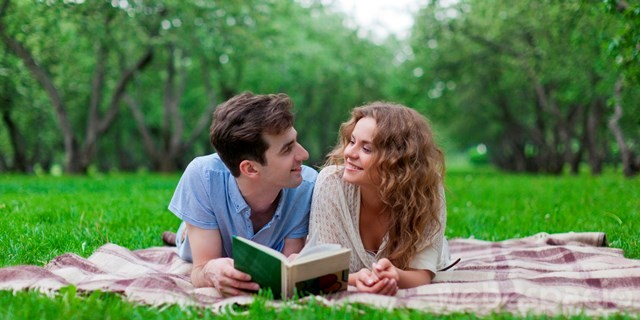 Young couple lying on blanket in park